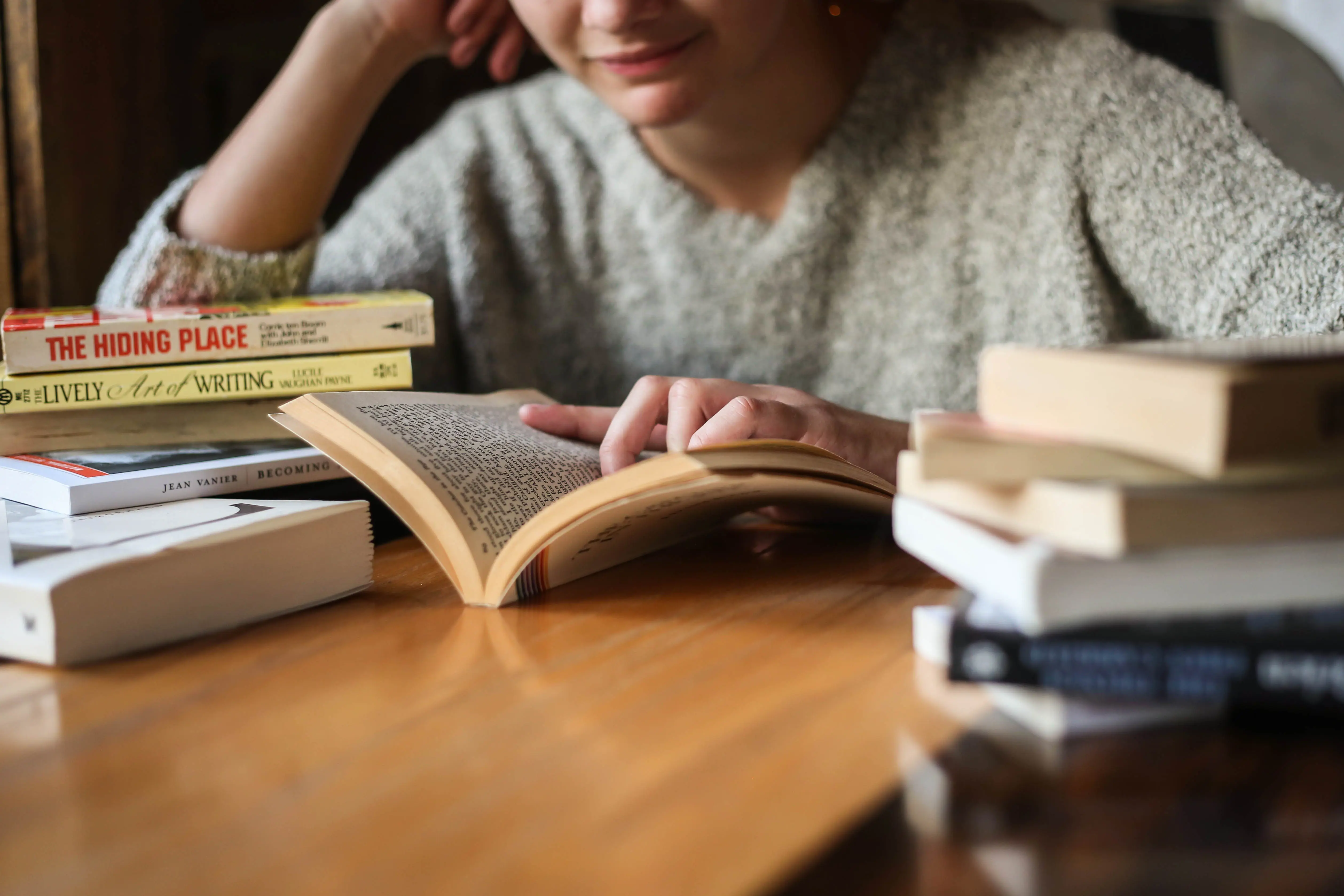 a person sitting at a table with books on it