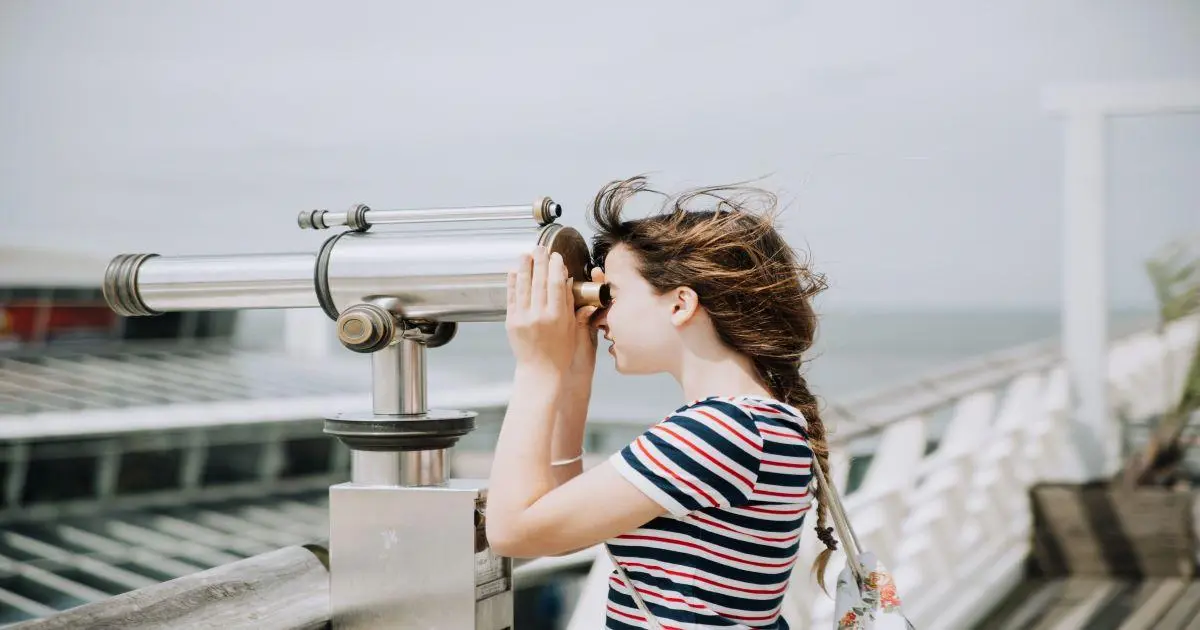a woman looking through a telescope